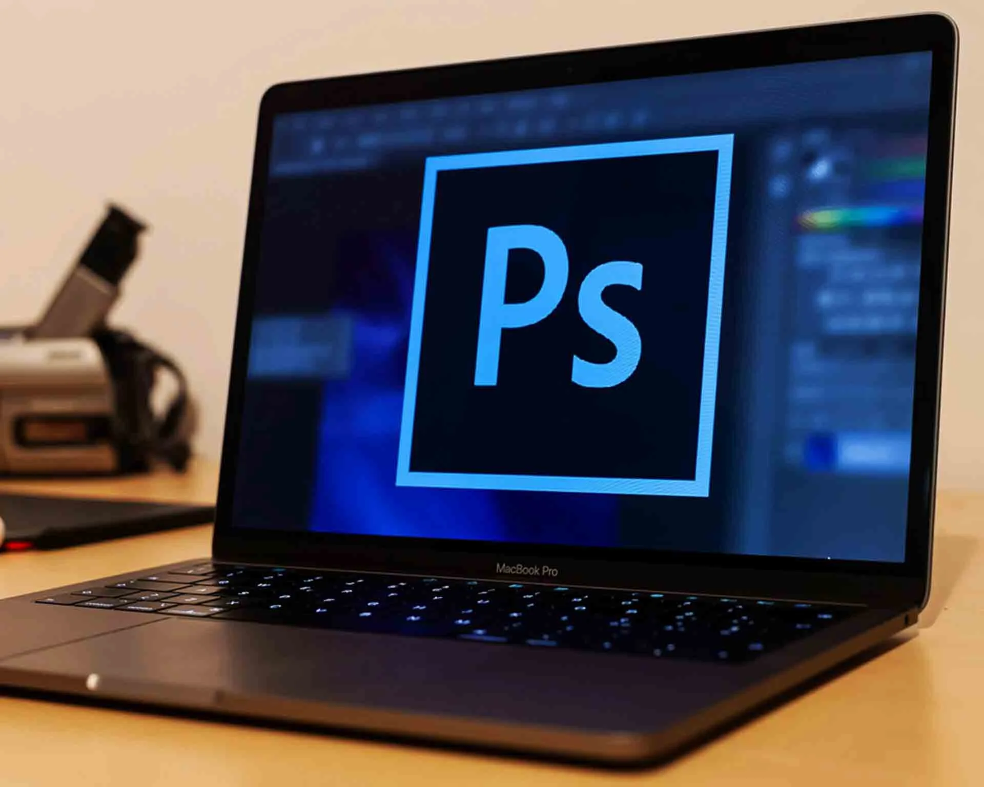 Computer screen displaying the Photoshop logo with a camera in the background of the frame